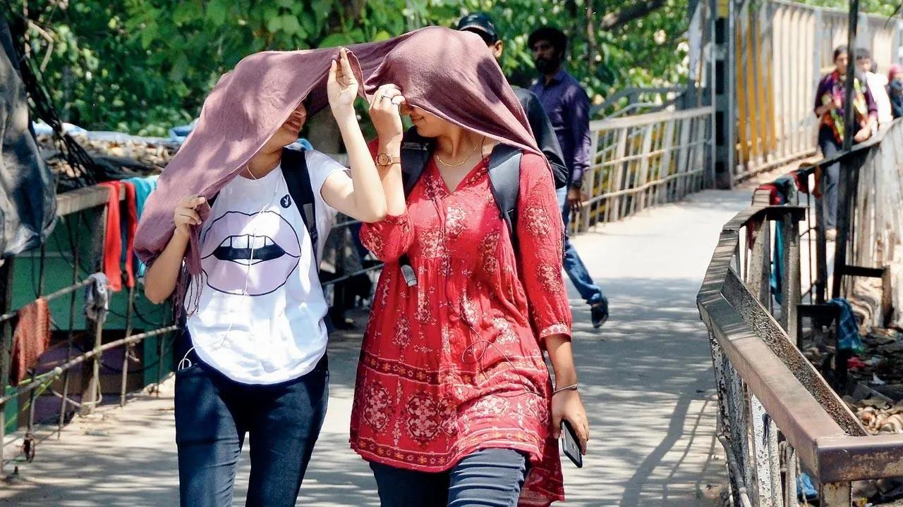 Undercover friends: Two girls shield themselves from the scorching sun with a stole at King’s Circle in Matunga on Tuesday. Pic/Sayyed Sameer Abedi